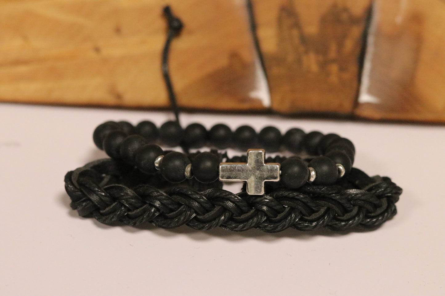 Black braided bracelet with a silver cross charm