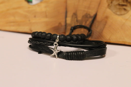 Black leather bracelet with a star charm on a wooden surface